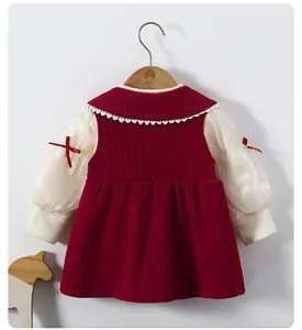 Detail eines roten Cordkleides für Mädchen mit Spitzenkragen und Puffärmeln