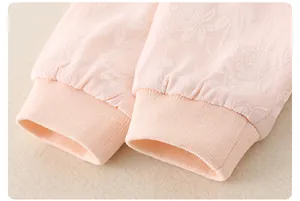 Macro shot of pink baby romper sleeves with rose jacquard fabric and rib-knit cuffs
