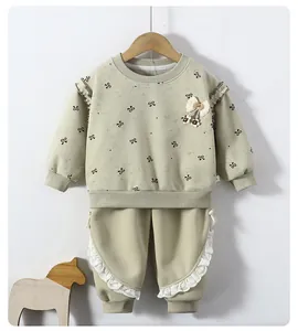 Detail of light green girls' sweatshirt set with lace edges and bow print pattern