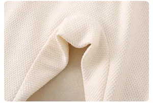 Gros plan détaillé du tissu en coton gaufré blanc doux pour barboteuses de bébé
