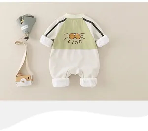 Detail eines Baby-Stramplers mit Löwen-Stickerei und grünem Patchwork-Design