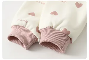 Close-up of soft ribbed pink cuffs and heart pattern print on toddler cotton sweatshirt