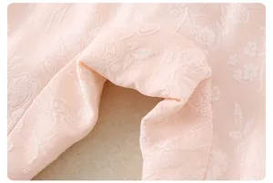 Macro shot of light pink rose jacquard fabric showing delicate floral textures