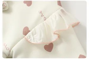 Detail of baby girl sweatshirt with heart prints, satin ruffles and knit texture