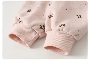 Close-up of pink children's sweatshirt with rib-knit cuffs and bow print detail
