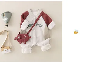 Detail of baby romper with HUP PYS letters and cute elephant bag on cream background