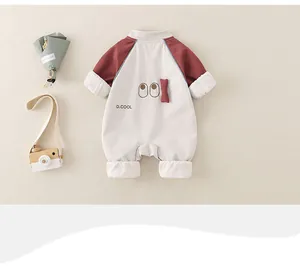 Detail of baby romper featuring cartoon eyes, D.COOL print, and 3D bone ornament