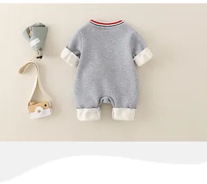 Close-up of grey long-sleeve baby romper with red striped collar and cream cuffs