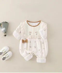 Detailansicht eines Baby-Stramplers mit Waffelstrick, Blumenstickerei und kleiner Schleife