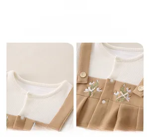 Detailed view of floral embroidery and bow accents on soft ribbed cotton baby romper