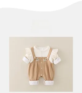 Detail of baby romper with ruffle sleeves, floral embroidery and snap buttons