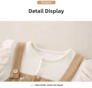 Detailed close-up of knit fabric and floral embroidery on baby jumpsuit overalls