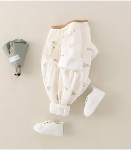 Flachbild von Neugeborenen-Blumenbody mit Rüschenkragen und weichen Babyschuhen