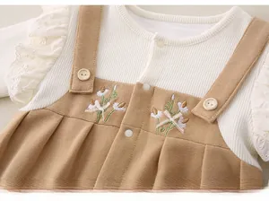 Detail of floral embroidery and 3D bow on baby long sleeve romper with lace trim
