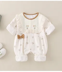 Detailansicht der Blumenstickerei und Rüschen an diesem Baby-Einteiler aus Baumwolle