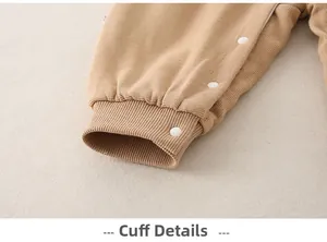 Close-up of ribbed cotton baby romper leg cuffs with durable white resin snap buttons