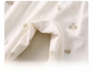 Detail der verbreiterten Schrittpartie und des floralen Strickstoffs am Baby-Strampler