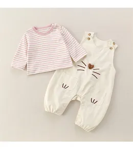 Detail of baby overalls set with striped t-shirt and cute cat embroidery details