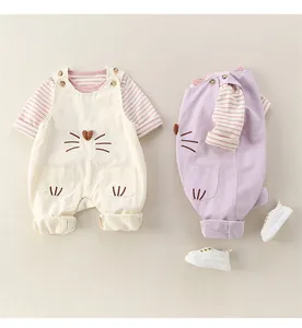 Detail of baby overalls set with cartoon cat face embroidery and striped long sleeve top