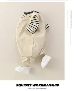 Tenue de bébé avec haut rayé et salopette cargo kaki à poches en vue à plat