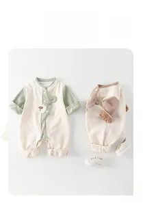 Detail of baby romper with bear embroidery and contrast sleeves in soft waffle knit