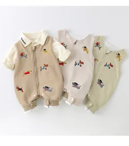 Detailed view of three baby rompers with cute dog embroidery in khaki, cream and green