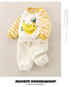 Detail of infant cotton set featuring banana cartoon sweatshirt and striped sleeves