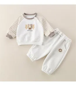 Detail-Flachbild von weichem Baumwoll-Babysuit mit Bärenmotiv und gestreiften Ärmeln