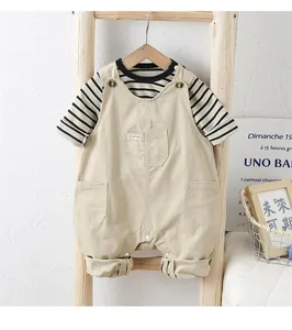 Détail de t-shirt rayé pour bébé garçon et salopette en coton beige sur échelle