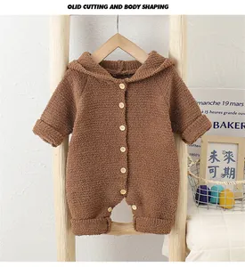 Detail of baby hooded romper in brown fleece fabric with wooden buttons and crotch snaps