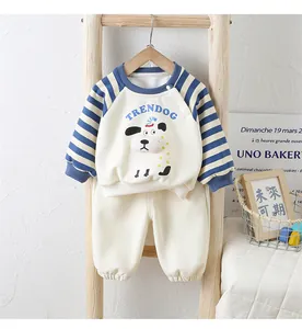 Detail of baby tracksuit featuring cartoon dog print and striped sleeves on wooden ladder