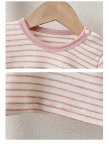 Detail of pink striped baby romper with shoulder snaps and soft knit cotton fabric