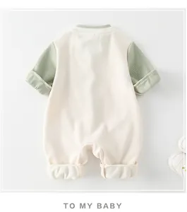 Detail view of waffle texture fabric on long-sleeve baby romper in cream and sage green