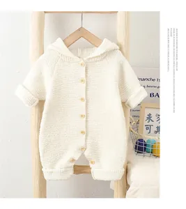 Detail of baby hooded romper in cream fleece fabric with decorative wooden buttons