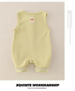 Detailansicht eines gelben Baby-Bodys aus Baumwolle mit Bärenaufnäher und Rippbündchen