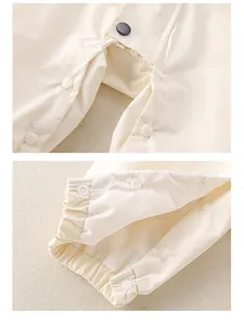 Detail view of baby romper snap closure and elastic cuffs on windproof fabric