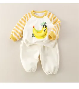 Detail of infant cotton set featuring ivory banana print sweatshirt and white joggers