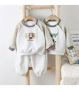 Details von zwei Bio-Baumwolle Baby-Sweatshirts mit Bären-Patch und Streifenärmeln