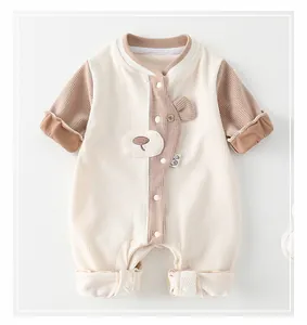 Detail of baby romper with waffle fabric texture, bear decoration and snap buttons