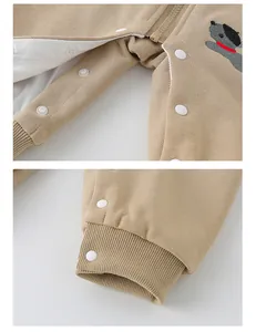 Detail of baby cotton jumpsuit with snap buttons, ribbed cuffs and puppy embroidery