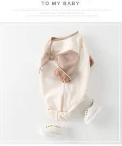 Flat lay of baby waffle cotton romper with side buttons and matching canvas sneakers