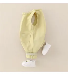 Detail eines hellgelben Baby-Stramplers aus Baumwolle mit Reißverschluss und Tasche