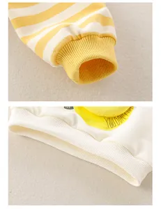 Detail of yellow striped cuffs and ribbed hem on baby cotton cartoon sweatshirt