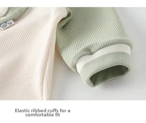 Detail of elastic ribbed cuffs and waffle knit texture on a baby romper