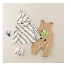 Dettaglio del set neonato con felpa a righe e salopette dinosauro color kaki
