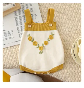 Détail du barboteuse en tricot pour bébé avec broderies florales 3D et boutons en bois