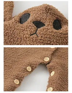 Detail of brown fleece baby romper featuring bear hood embroidery and snap button closure