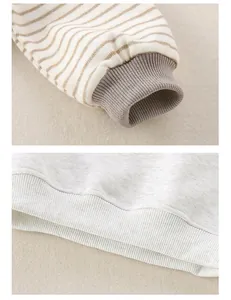 Detailansicht der gestreiften Baumwollärmel und Rippbündchen am weichen Babypullover