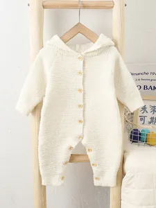 Infant hooded cream fleece romper with wood buttons hanging on a wooden ladder