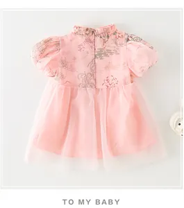 Détails de la robe rose bébé avec col chinois, imprimés rétro et jupe en tulle multicouche
